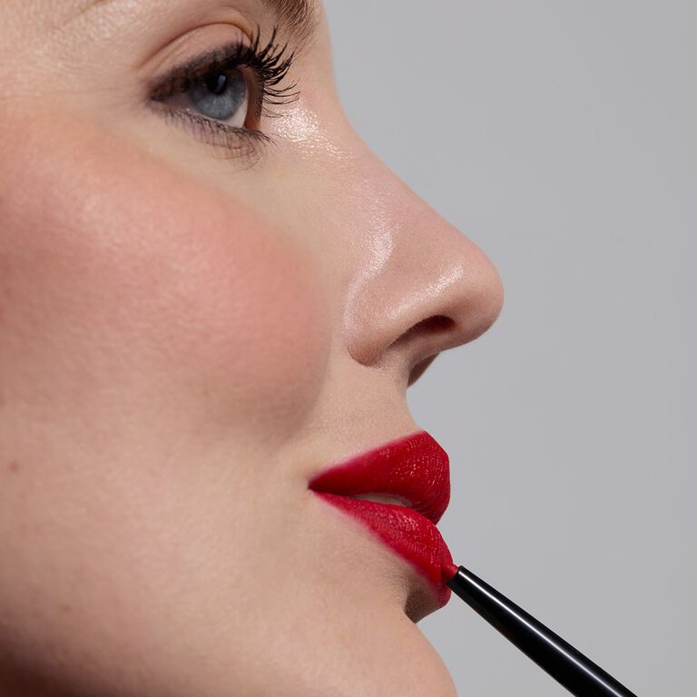 Mujer maquill&aacute;ndose los labios